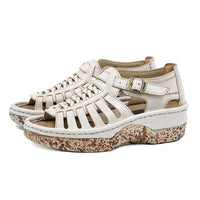 Cream sandals with a patterned sole on a white background