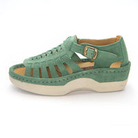 A pair of women's open-toe sandals in a mint suede, featuring cutout straps, a braided front design, adjustable ankle straps with silver buckles, and white soles.