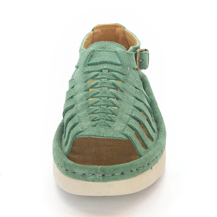 A pair of women's open-toe sandals in a mint suede, featuring cutout straps, a braided front design, adjustable ankle straps with silver buckles, and white soles.
