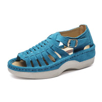 A single women's platform sandal in a vibrant teal blue suede-like material, featuring cutout straps, a side buckle strap, and a thick light gray platform sole, shown against a plain white background.