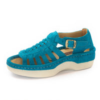 A turquoise blue suede platform sandal with cutout straps, a buckle strap, and a thick cream-colored platform sole, shown from a side profile on a white background.