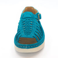 A single turquoise suede sandal with a  side buckle strap, and off-white sole, shown from a front-facing angle on a white background.