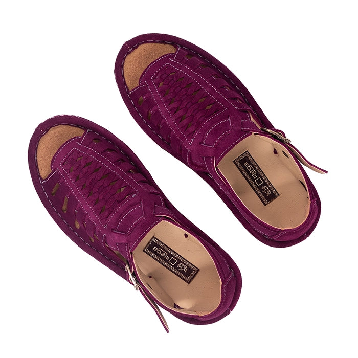 Pair of purple sandals with cut-out design on a white background