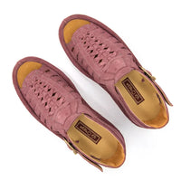 A pair of strappy sandals in lilac suede, featuring a cutout design, braided detail across the front, an adjustable ankle strap with a gold-tone buckle, and a low wedge heel. The brand 'Omega' is visible on the buckle.