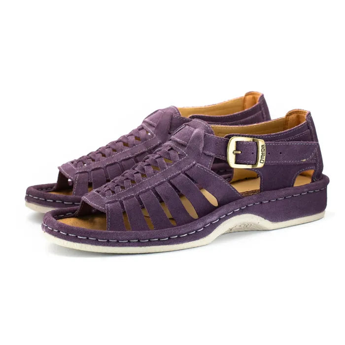 A pair of strappy sandals in purple suede, featuring a cutout design, braided detail across the front, an adjustable ankle strap with a gold-tone buckle, and a low wedge heel. The brand 'Omega' is visible on the buckle.