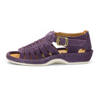 A shoe with strappy sandals in purple suede, featuring a cutout design, braided detail across the front, an adjustable ankle strap with a gold-tone buckle, and a low wedge heel. The brand 'Omega' is visible on the buckle.