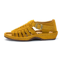 A single strappy sandal in mustard yellow suede, featuring a buckle strap, braided front straps, and a wedge sole, shown against a plain white background.