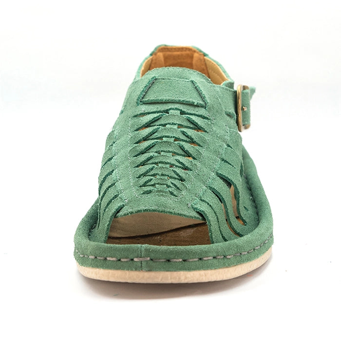 A mint green suede wedge sandal with a multi-cut strap design, a gold buckle, and a white sole, shown in a side profile on a white background.