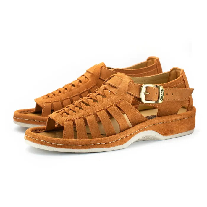 A pair of peach coloured suede sandals with cutout straps, braided detailing, and adjustable ankle buckles, shown on a white background.