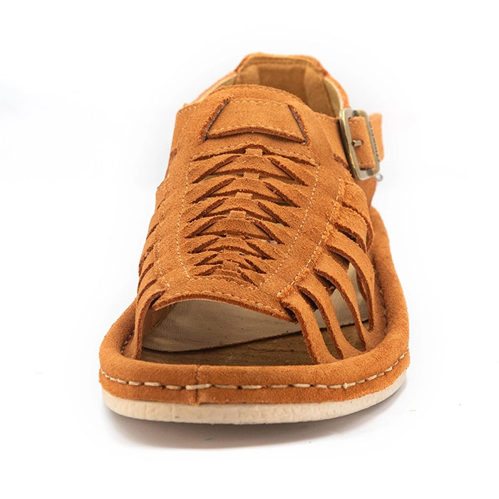 A single sandal in peach coloured suede, featuring a multi-cut strap design, an adjustable ankle strap with a gold-tone buckle, and a thick white sole.