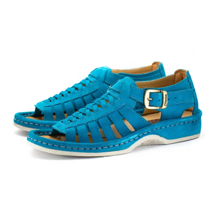 A pair of bright turquoise blue suede sandals with cutout straps, a buckle strap, and a white sole, shown on a white background.