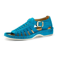 A single sandal in turquoise suede, featuring a multi-cut strap design, an adjustable ankle strap with a gold-tone buckle, and a thick white sole.