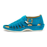 A single sandal in turquoise suede, featuring a multi-cut strap design, an adjustable ankle strap with a gold-tone buckle, and a thick white sole.