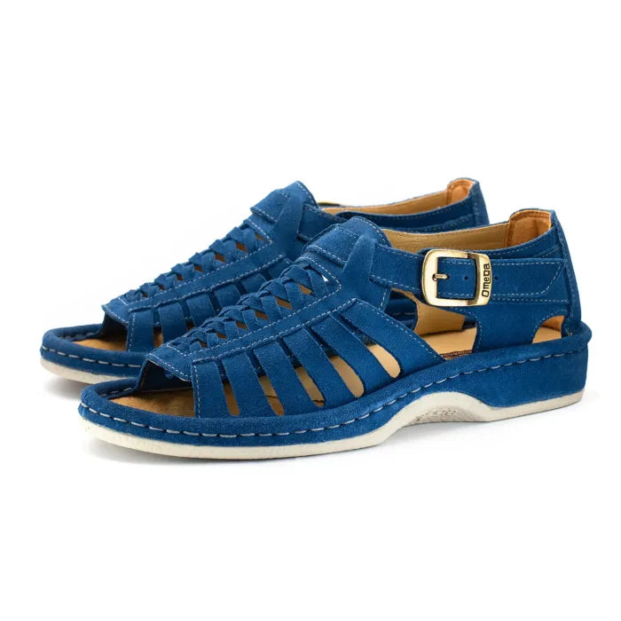 A pair of sandals in royal blue suede, featuring a multi-cut strap design, an adjustable ankle strap with a gold-tone buckle, and a thick white sole.