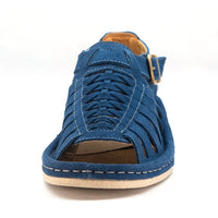 A single sandal in royal blue suede, featuring a multi-cut strap design, an adjustable ankle strap with a gold-tone buckle, and a thick white sole.