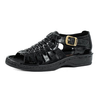 Black sandal with a gold buckle on a white background