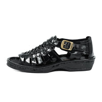 Black sandal with a gold buckle on a white background