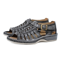 Pair of grey sandals with a buckle on a white background