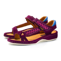 A pair of women's wedge sandals in deep cerise suede with woven pattern details on the straps, a tan interior, and blue heel accents, shown on a white background.
