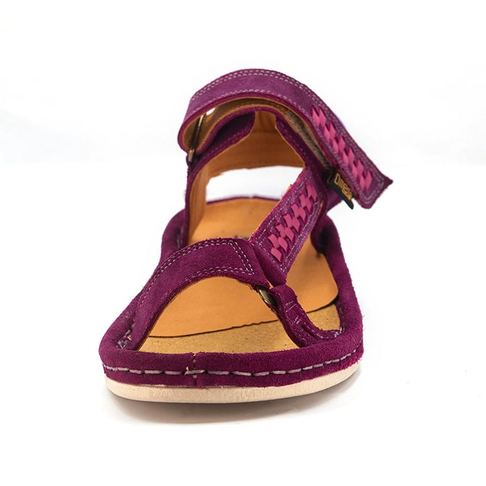 A single women's sandal in cerise suede with a pink woven pattern on the straps, a white sole, and a blue heel accent, shown against a plain white background.
