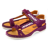 A pair of women's sandals in deep cerise suede with woven pattern details on the straps, a tan interior, and grey heel accents, shown on a white background.
